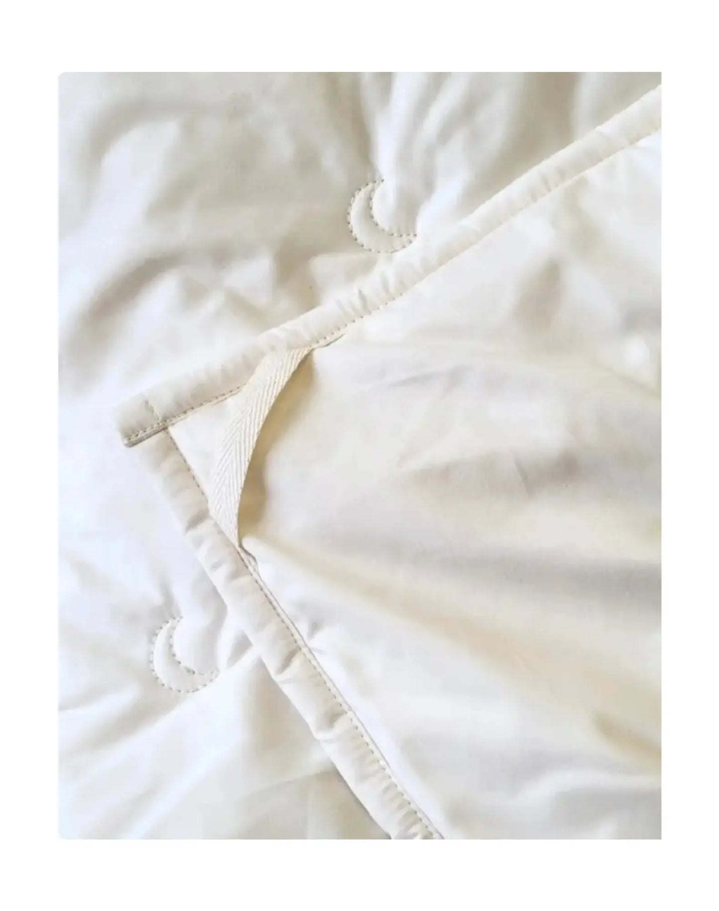 Corner tie detail on organic cotton comforter showing secure duvet attachment points