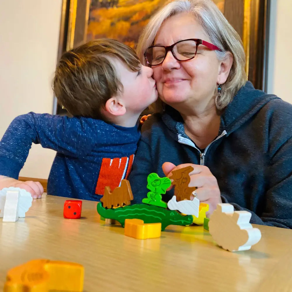 Child and grandparent playing Animal Upon Animal wooden stacking game together