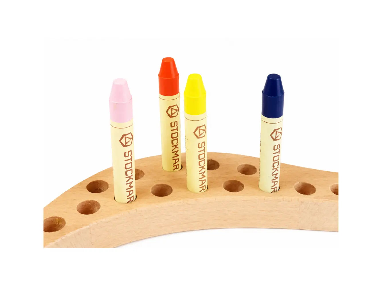 Close up of four colorful Stockmar stick crayons on a wooden crayon holder