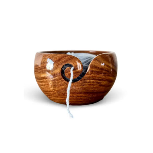 Wooden yarn bowl with a ball of yarn on a white background