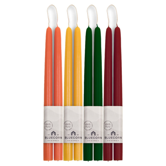 four pair taper candles in different autumn colors with visible labels on a white background