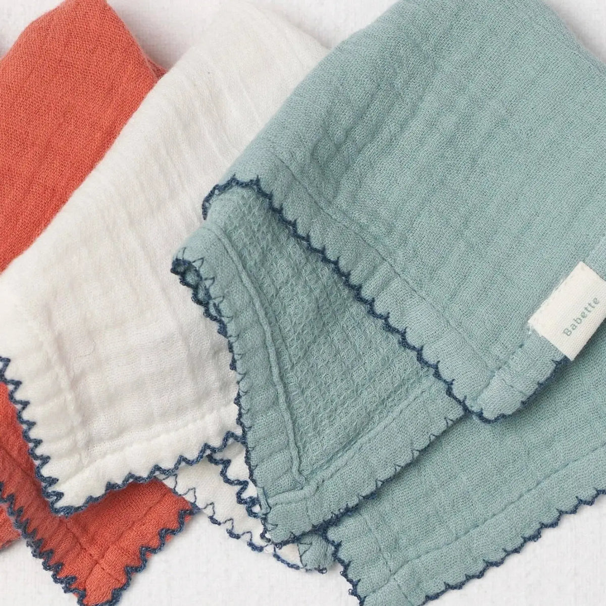 Stack of soft Babette cotton baby washcloths with scalloped edging close up detail
