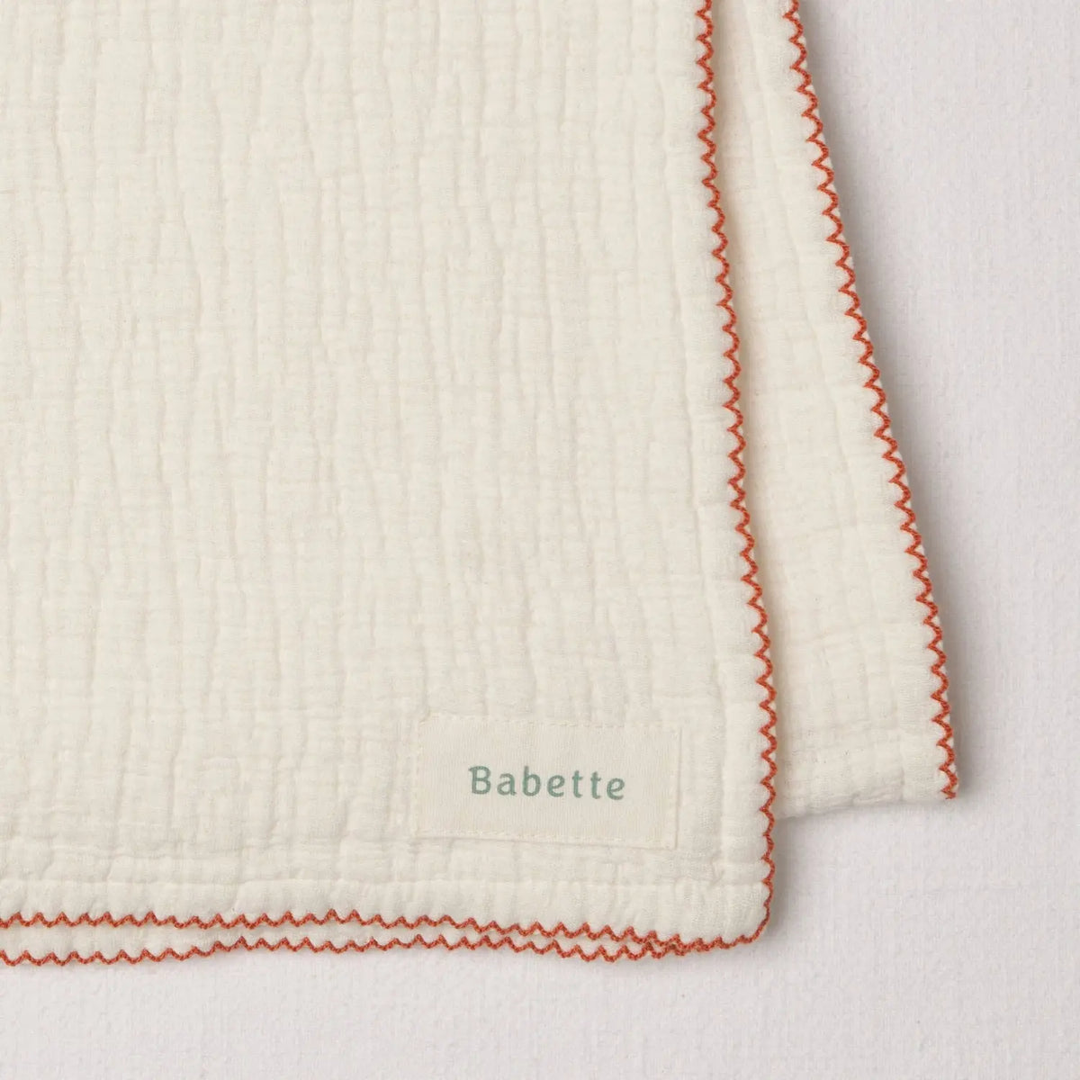 Babette thick plush white baby wrap with apricot scalloped trim and soft textured cotton fabric