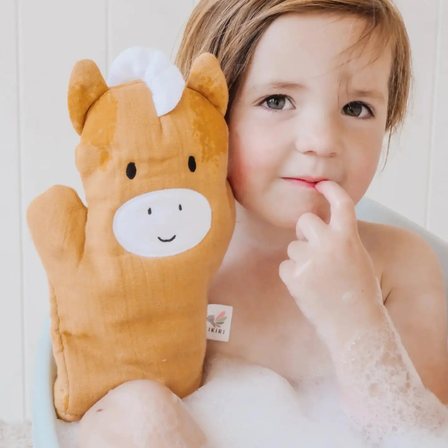 Horse baby bath mitt made of cotton muslin held by toddler in bathtub
