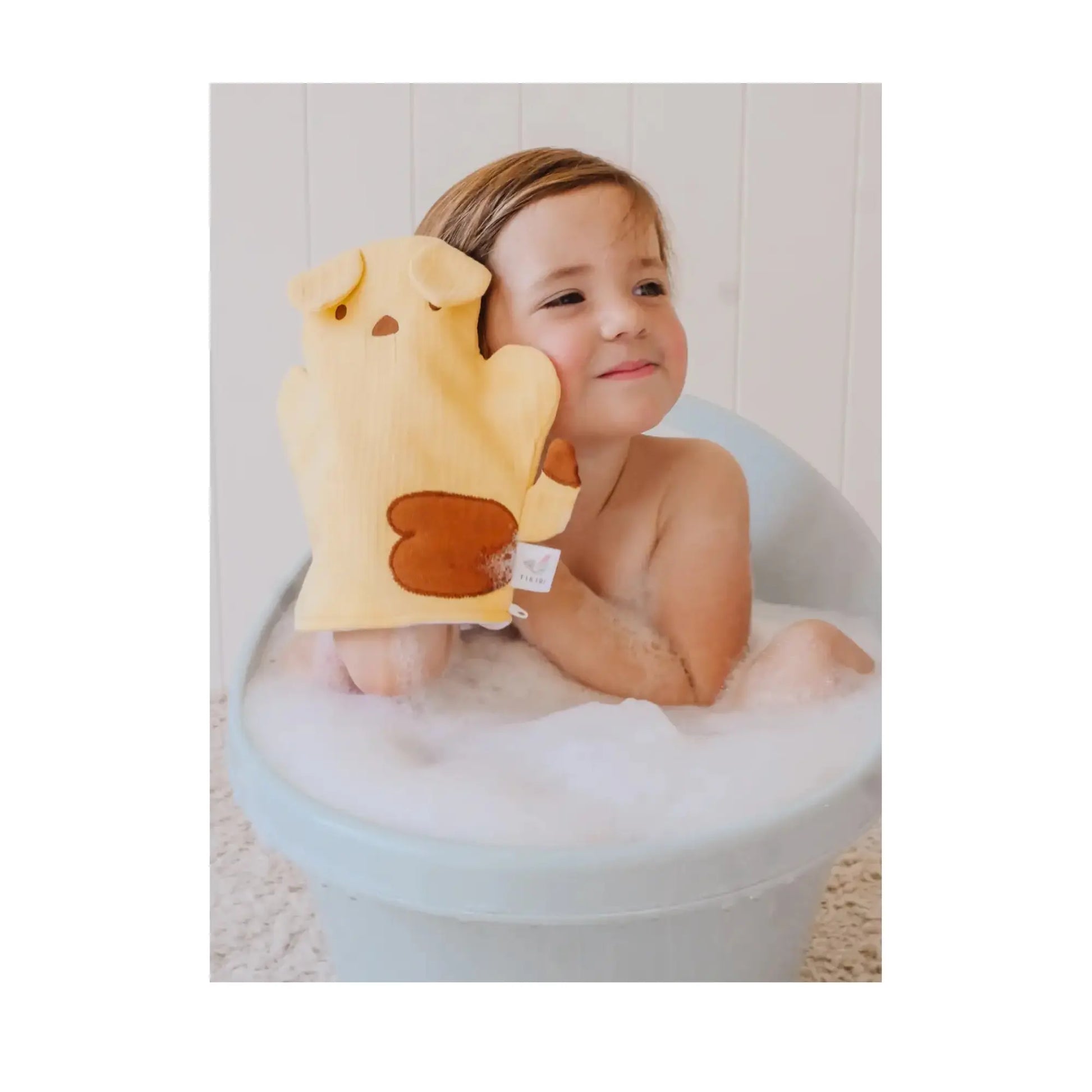 Puppy-shaped muslin bath mitt for babies, held by toddler during bath time