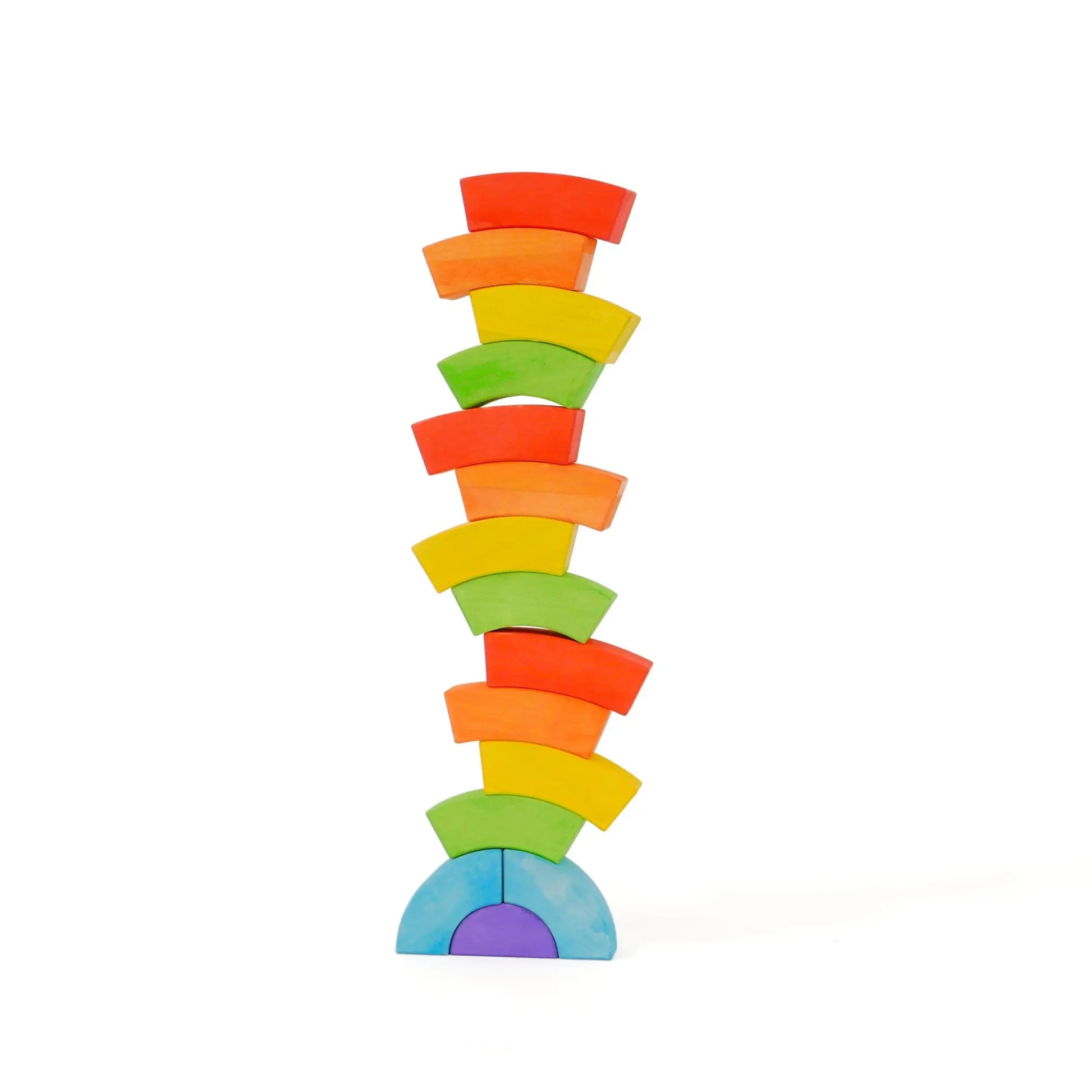BAJO wooden rainbow blocks balanced into a tall narrow tower on a white background