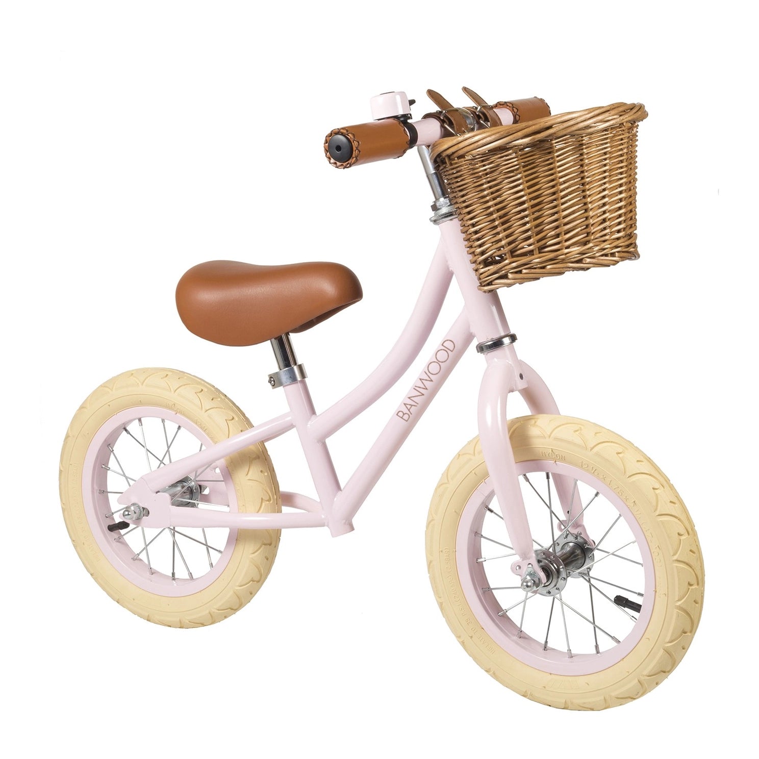 Pink balance bike with a wicker basket on a white background