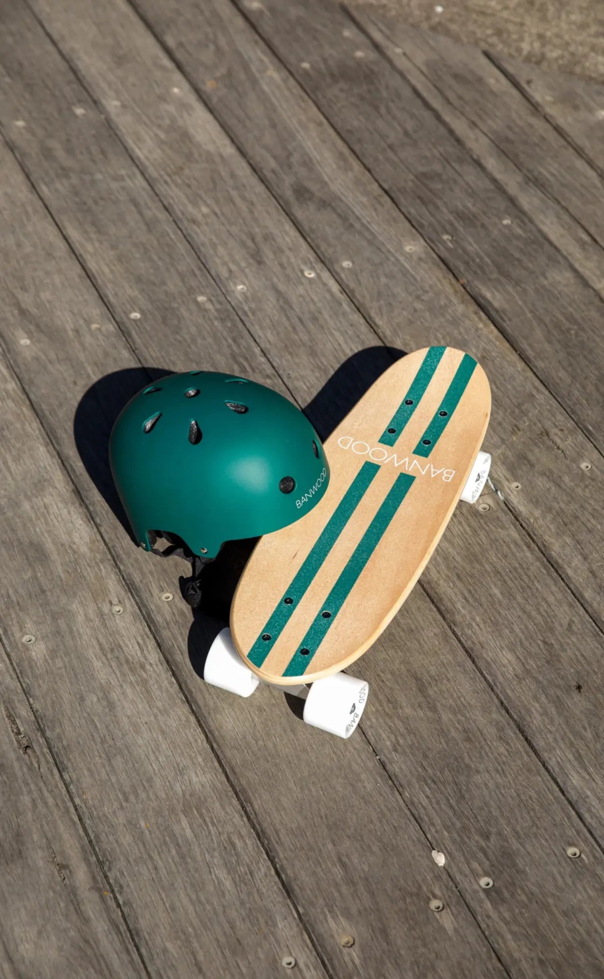 Skateboard with green helmet on a wooden surface