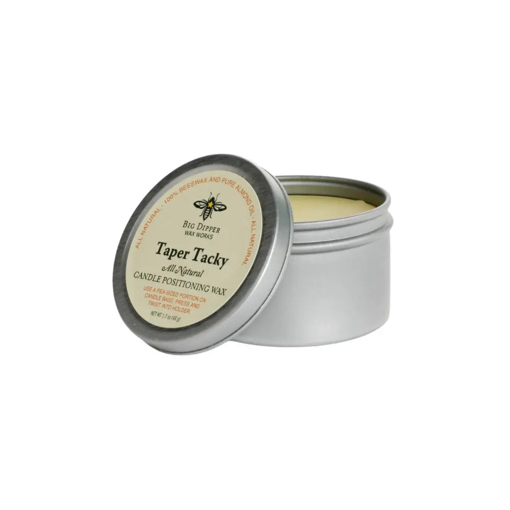 Open tin of beeswax taper candle adhesive wax showing adhesive wax for securing candles in holders
