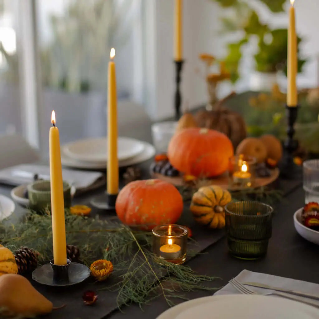 beeswax taper candles and tealights on an autumnal table