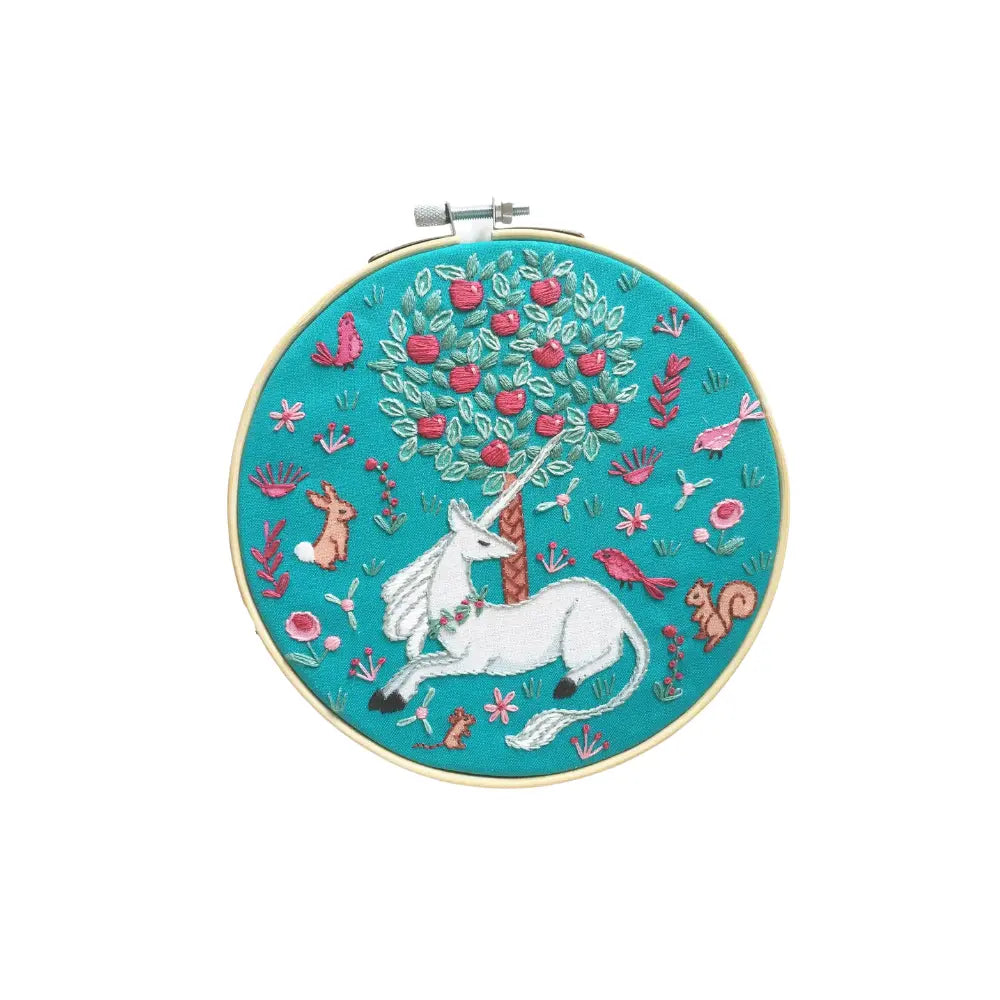 Embroidery hoop with a unicorn design on a teal background