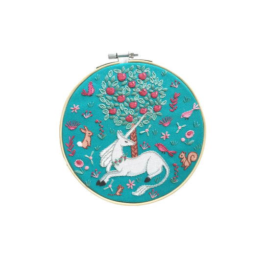Embroidery hoop with a unicorn design on a teal background