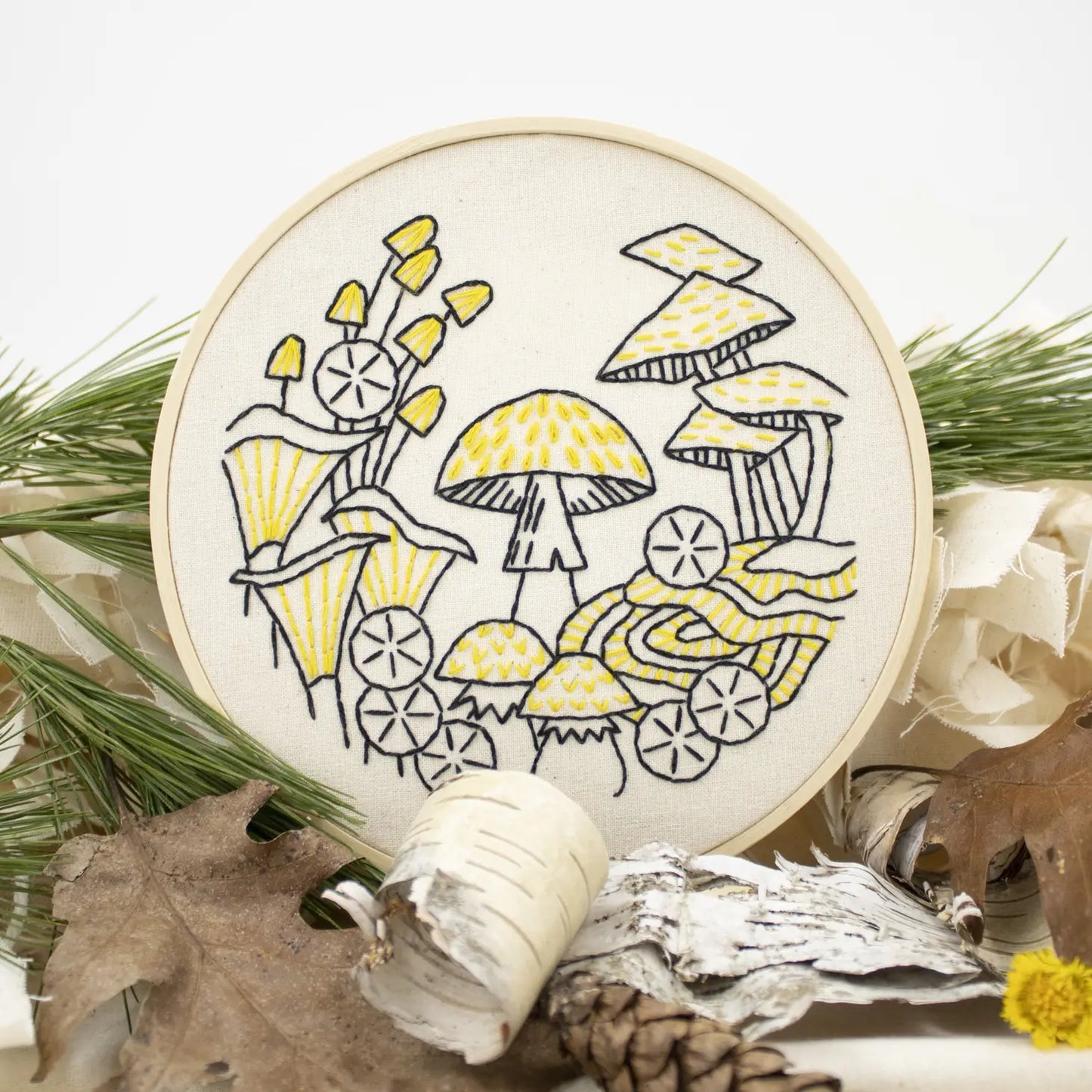 overview of a finished beginner mushroom embroidery kit in a nature scene