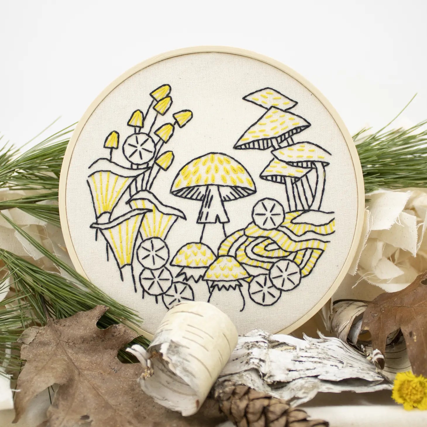 overview of a finished beginner mushroom embroidery kit in a nature scene