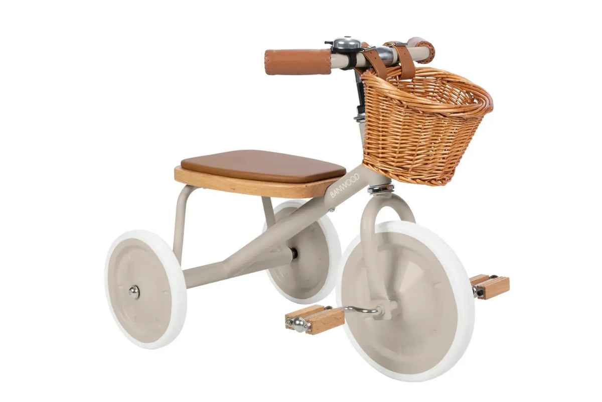 Children's tricycle with wooden seat and wicker basket on a white background