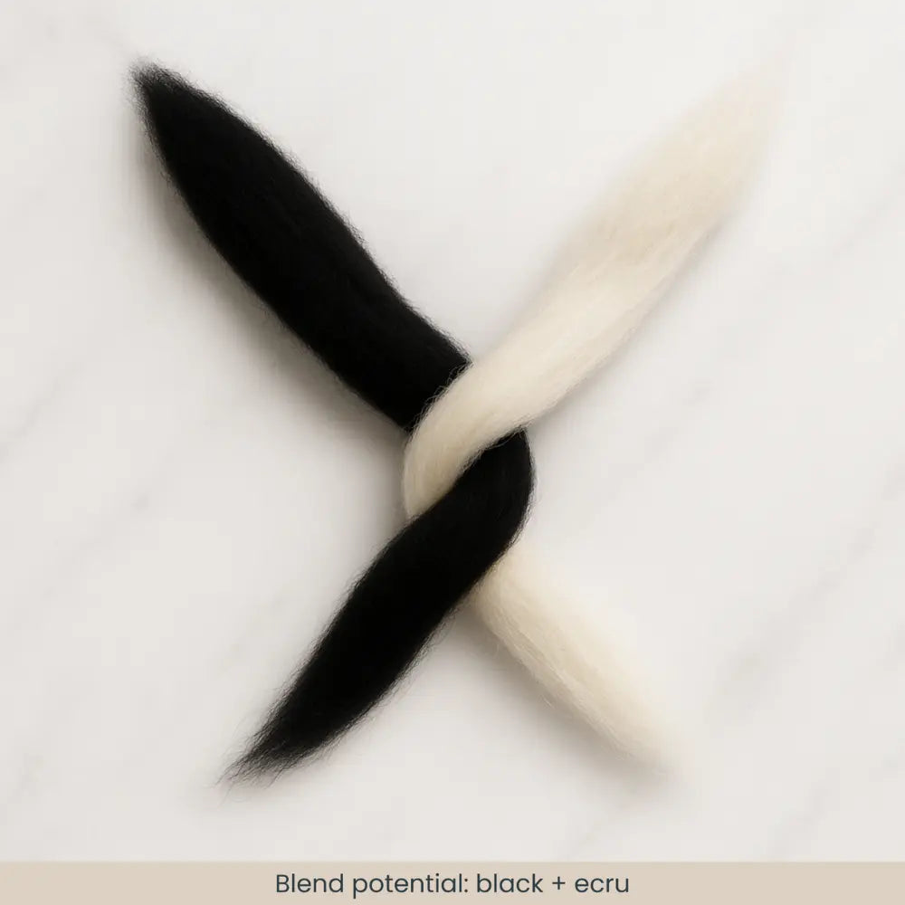 Black and ecru wool fibers criss crossed over each other
