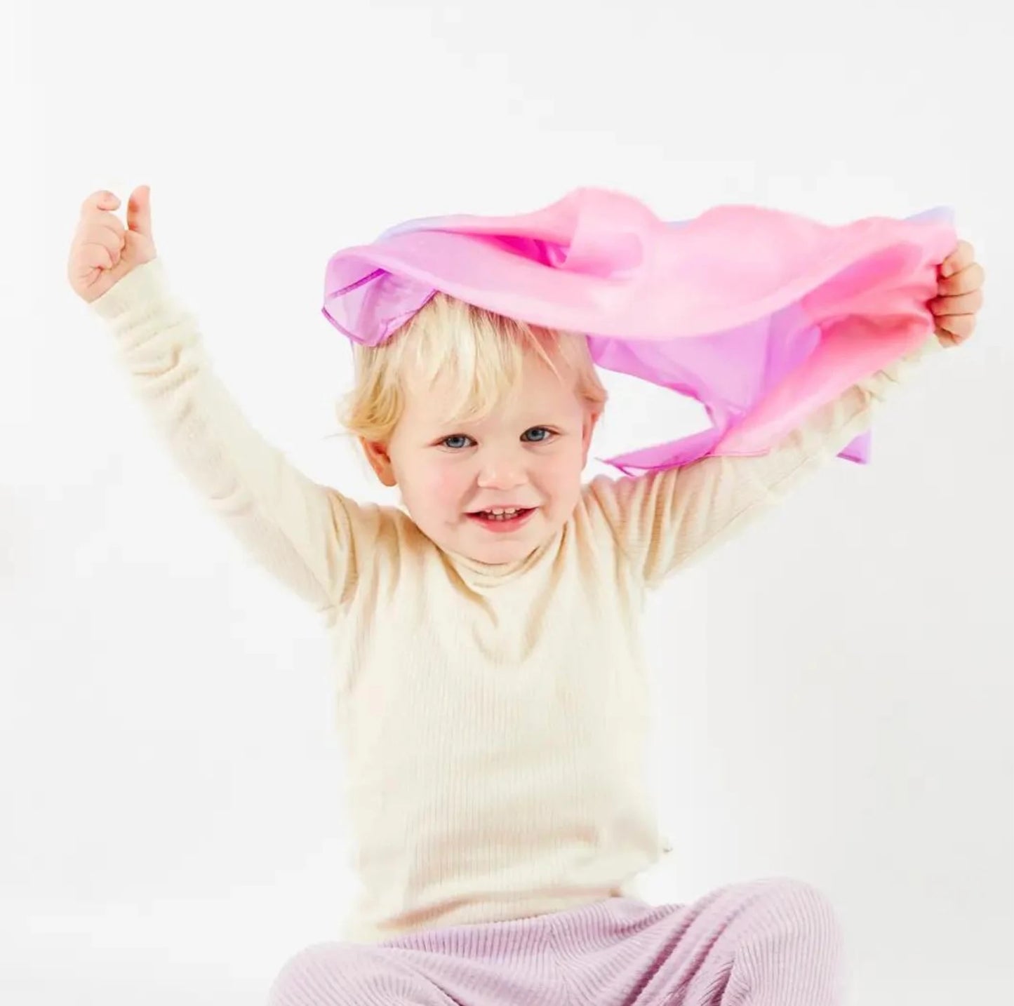 A toddler playing with Sarah’s Silks Enchanted Playsilk in Blossom