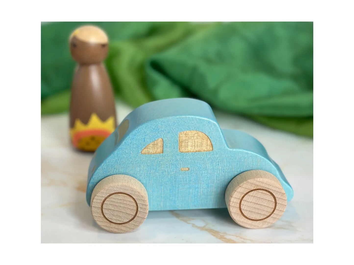 Blue wooden beetle toy car with rolling wheels side view