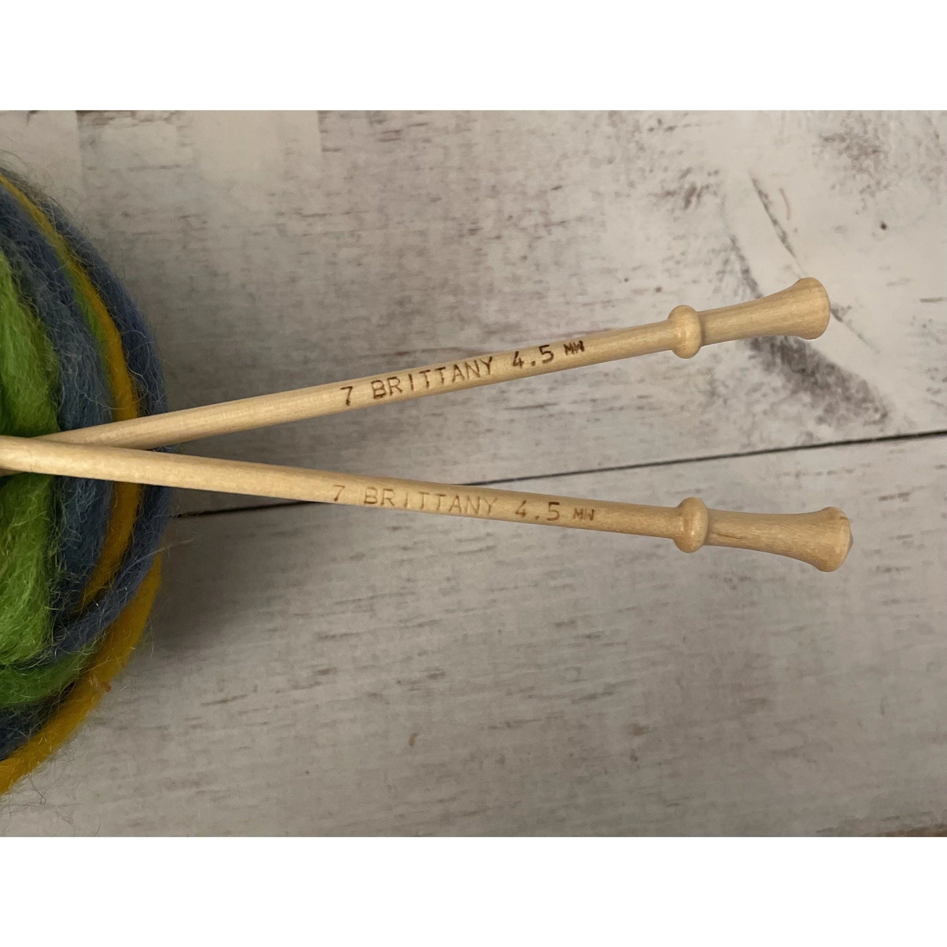 Close-up of Brittany birch wood knitting needle tips with green wool yarn