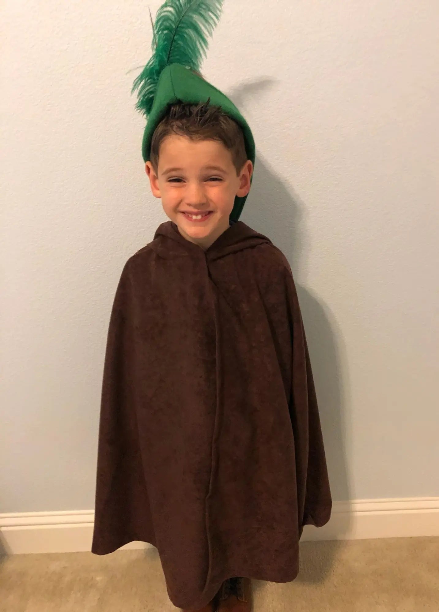Front view of brown hooded dress-up cape worn by child for storytelling and play
