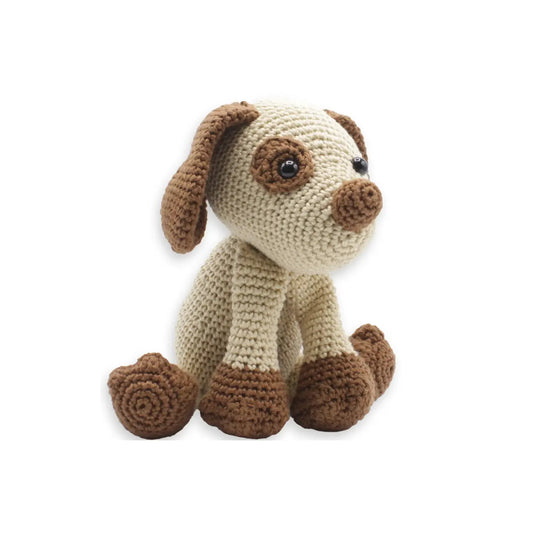 Finished puppy stuffed animal made from a crochet kit on white background