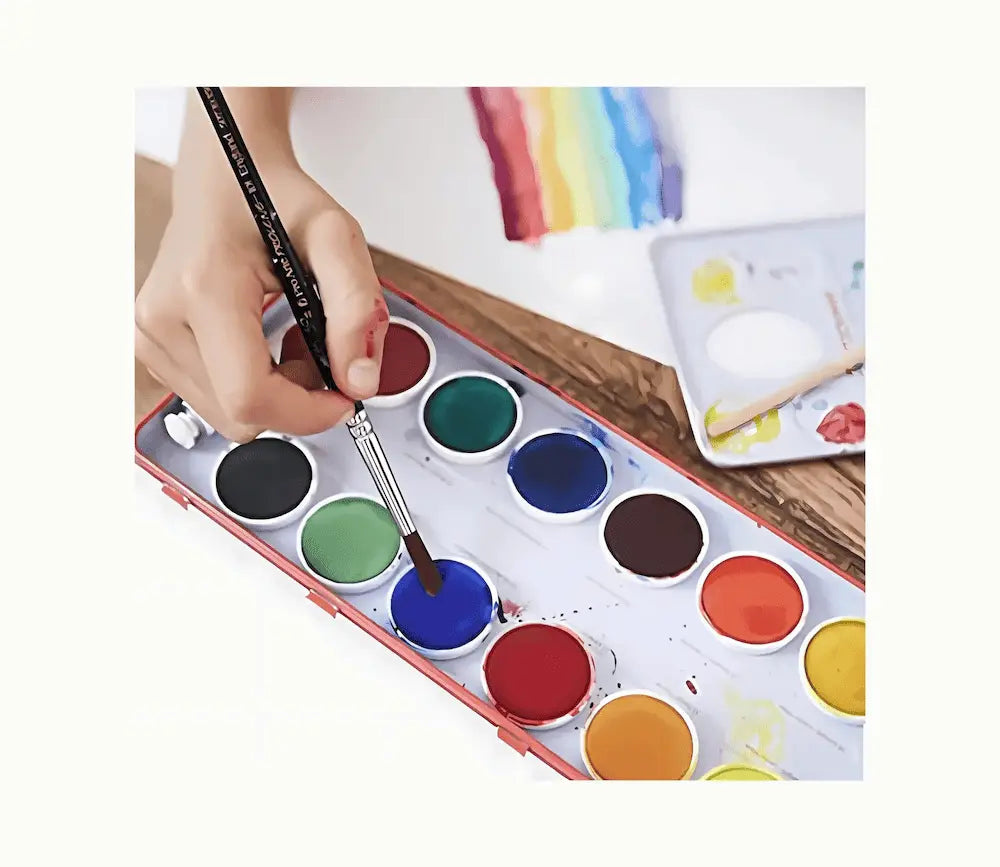 Watercolor paint set with a hand holding a brush and a colorful background.