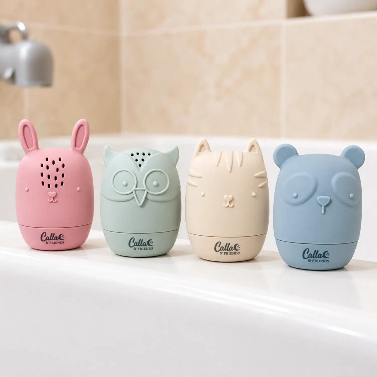 Pink bunny, sage owl, cream cat, and blue bear silicone bath toys lined up beside a bathtub