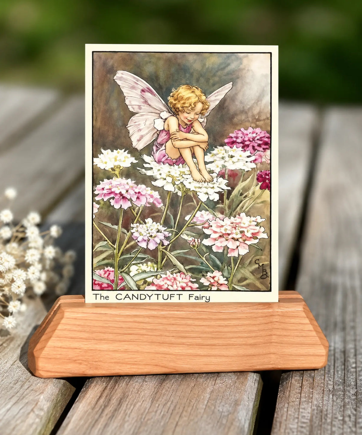 Candytuft flower fairy by Cicely Mary Barker in a wooden stand on a rustic table