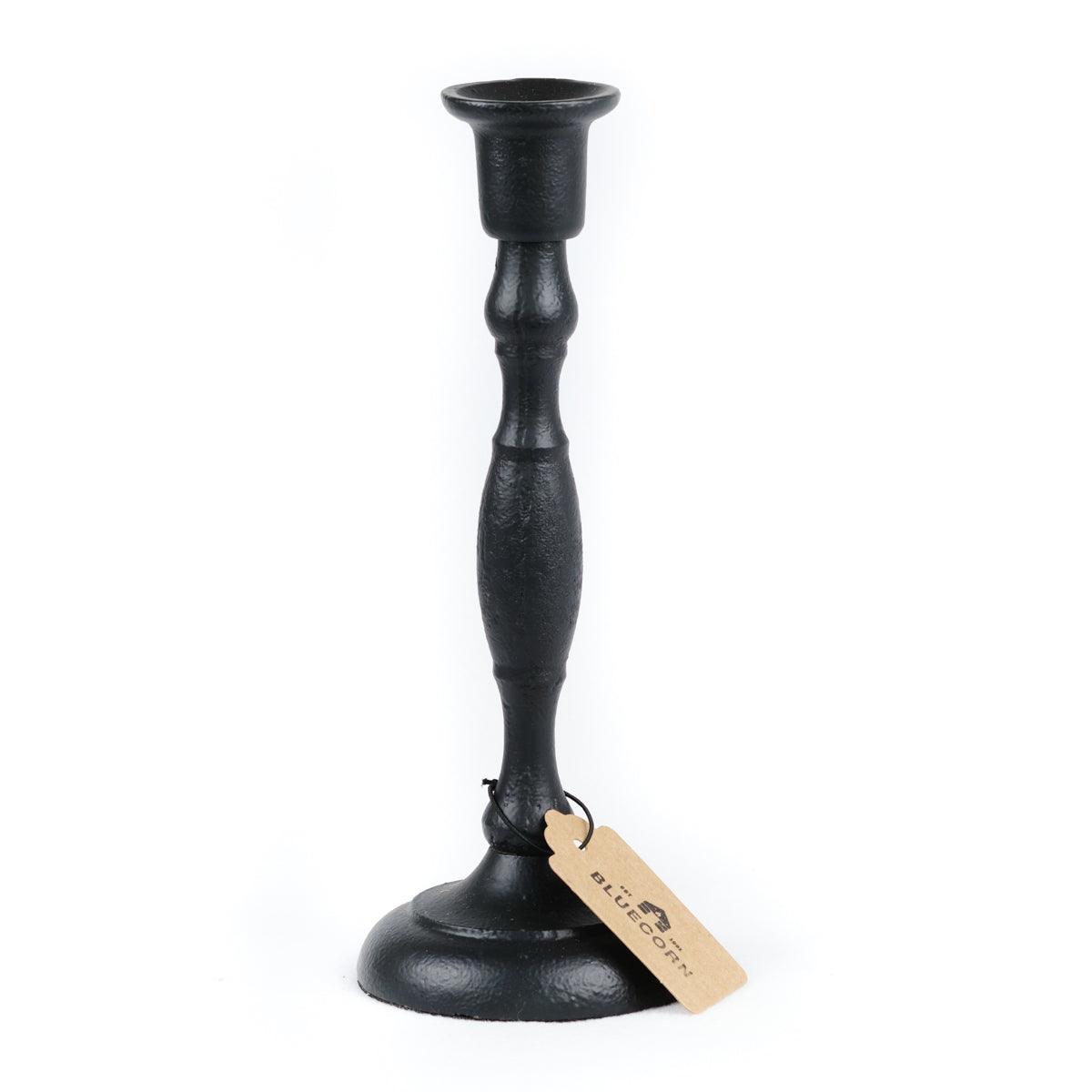 Black candlestick holder with a tag on a white background