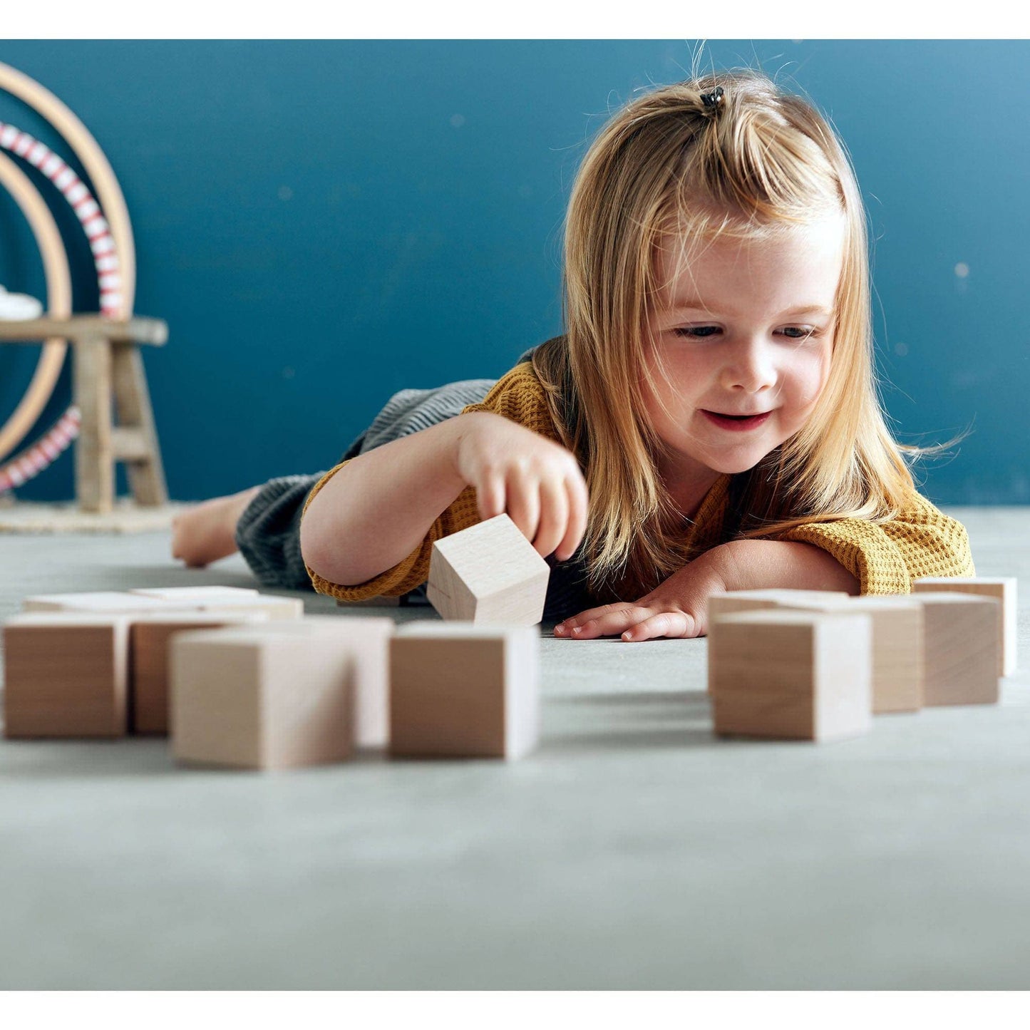 Child arranging wooden building blocks during hands-on construction play