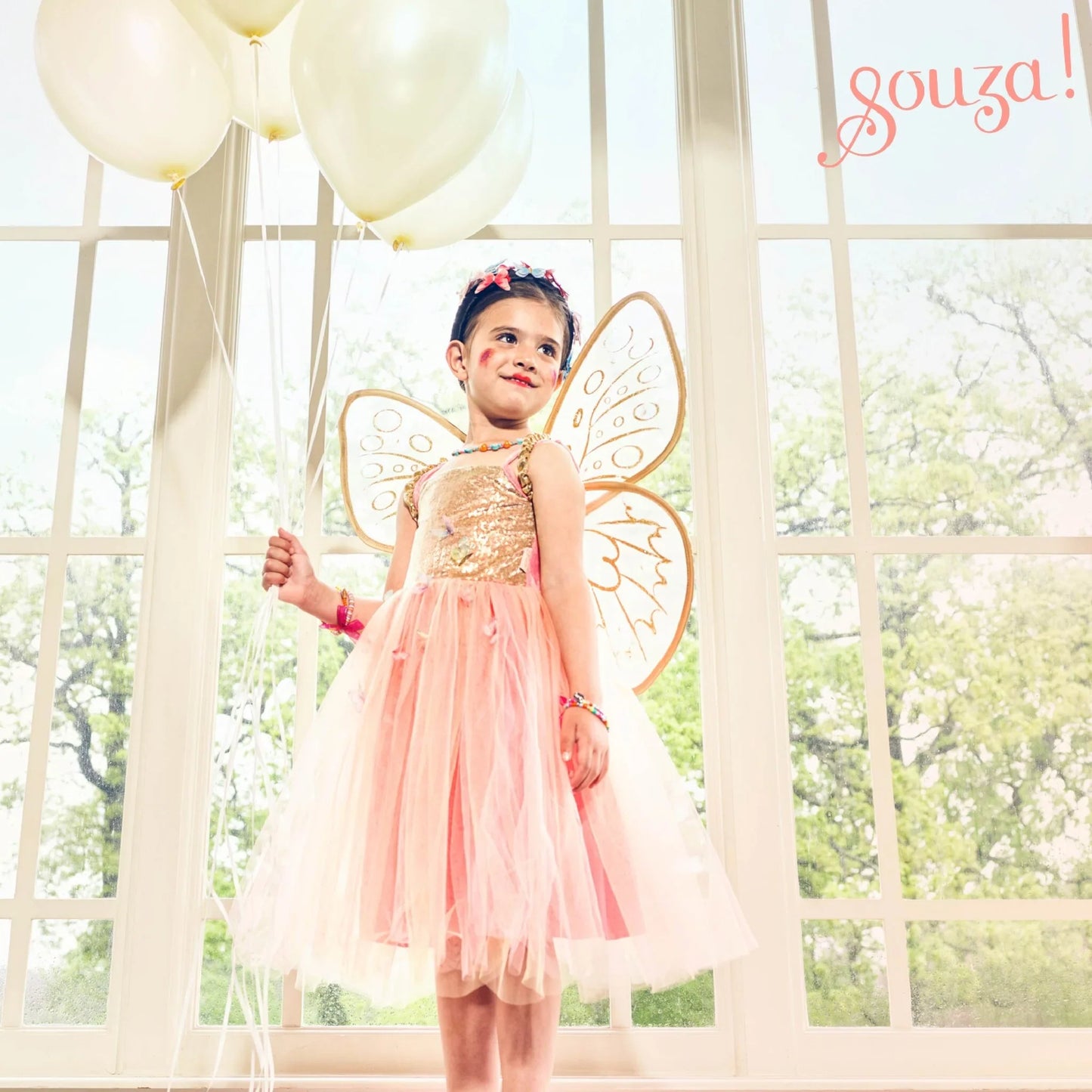 Child wearing apricot-orange fairy costume with wings for dress-up and storytelling