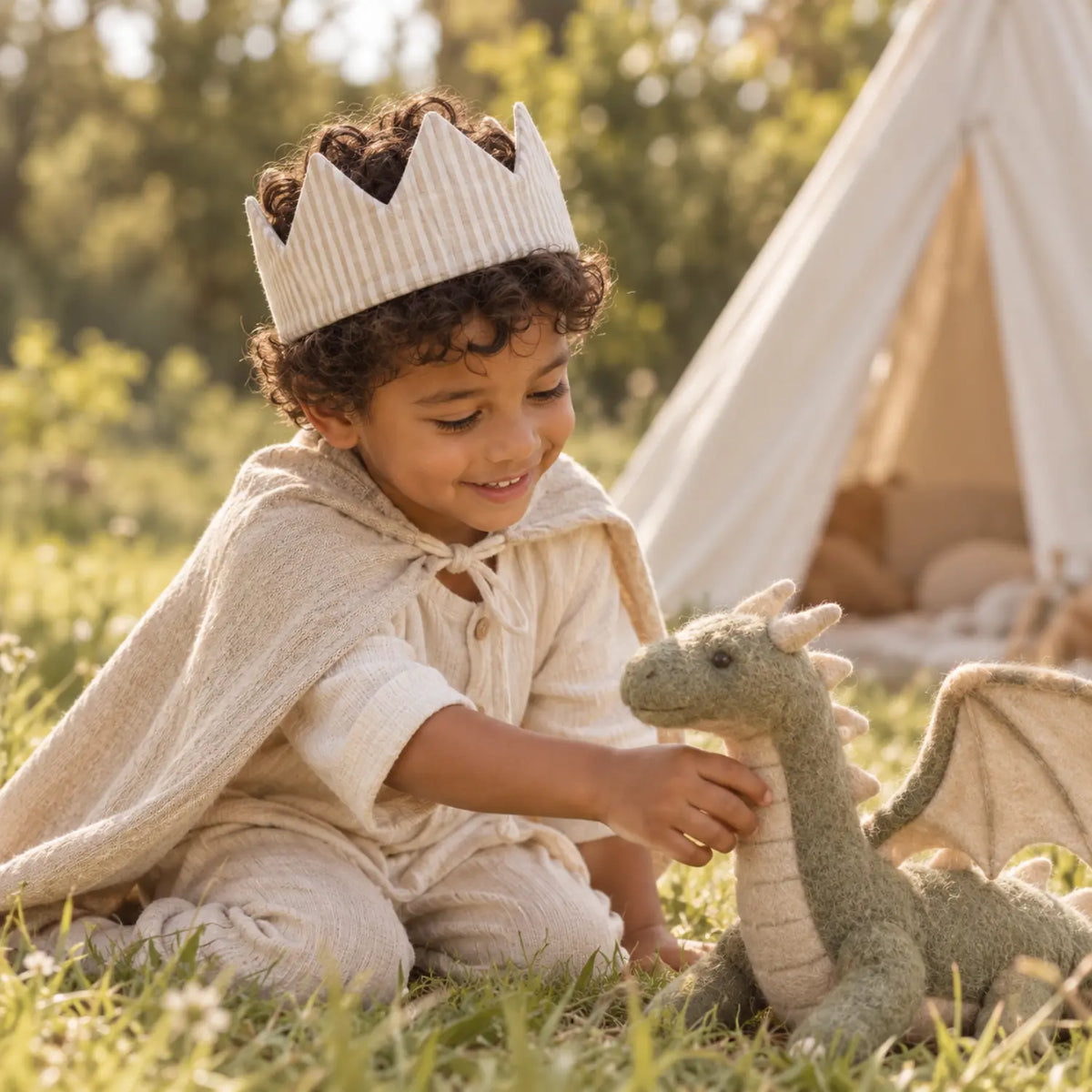 Preschool child wearing a beige striped linen crown during outdoor dragon pretend play