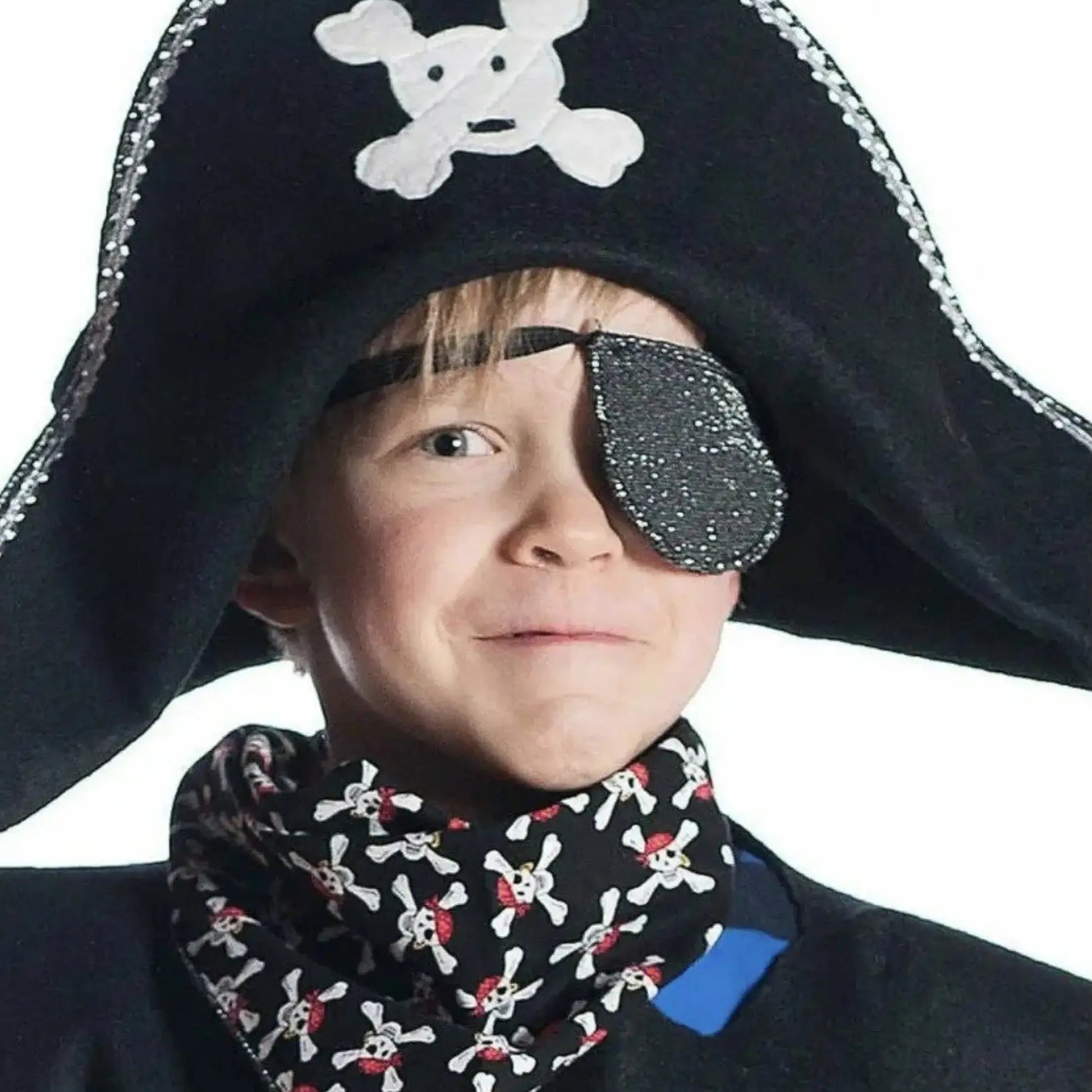 Child wearing a pirate costume with a black hat and eye patch on a white background