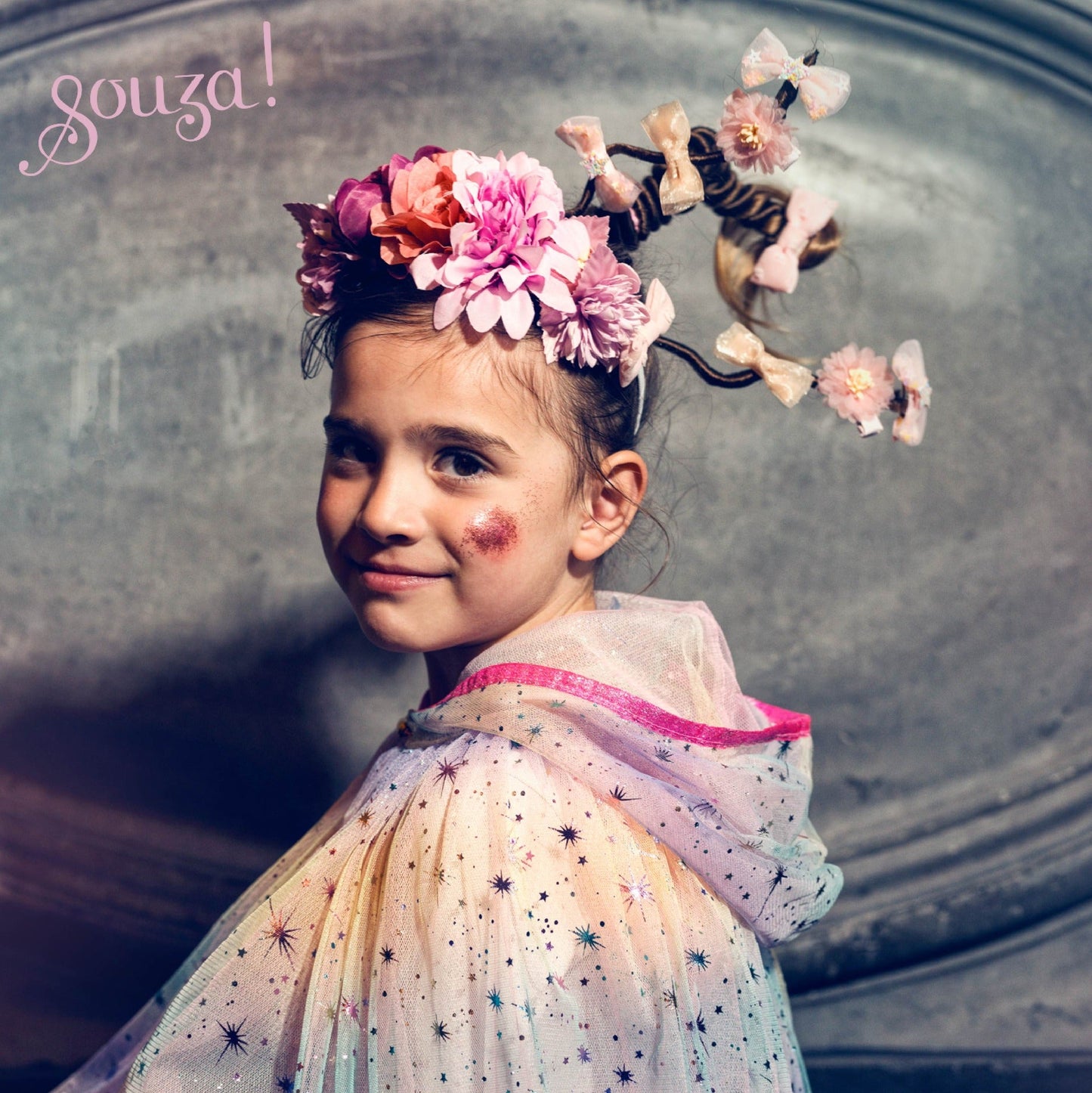 Child wearing rainbow tulle hooded cape for imaginative play and costume use