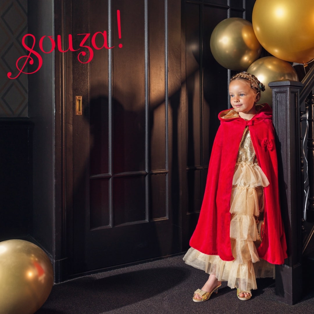 Child wearing red hooded cape for imaginative play and costume use