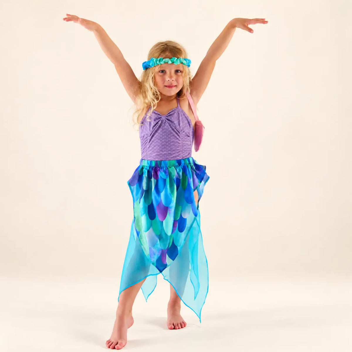 Child wearing the Rosette Sea silk garland as a headpiece with a blue silk skirt for dress-up play