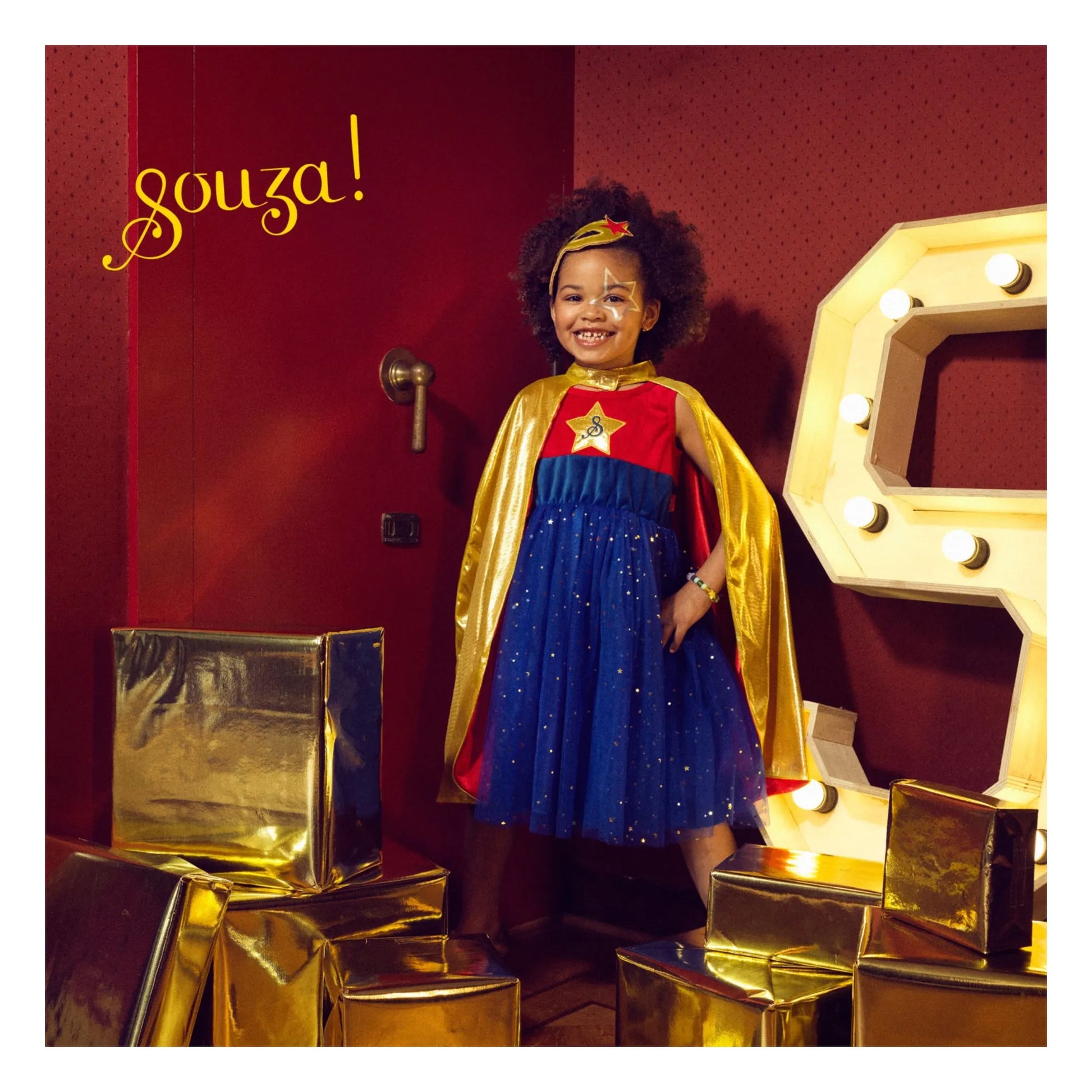 Child wearing superhero cape with dress for imaginative play and movement