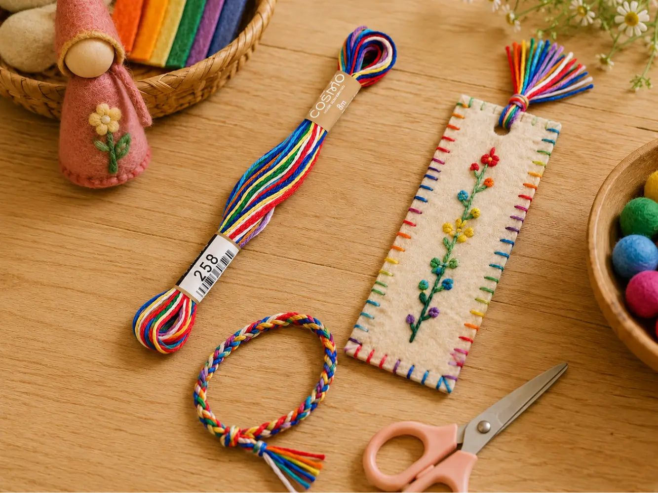 Colorful embroidery thread, scissors, and a embroidered bookmark and friendship bracelet