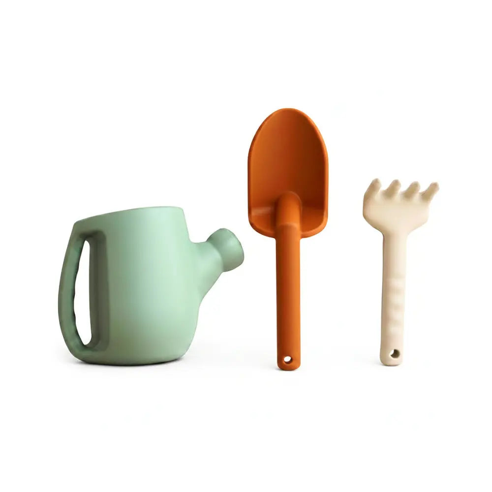 Set of children's silicone gardening tools including a watering can, spade, and fork on a white background.
