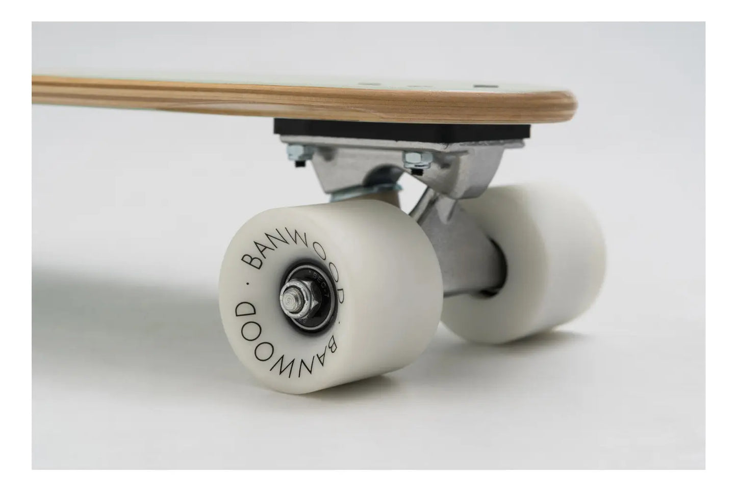 Close-up of a skateboard with white wheels on a light gray background