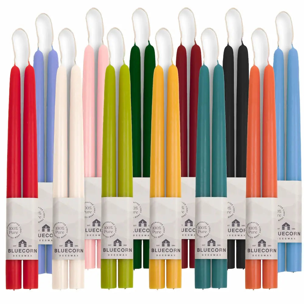 Set of colorful candles in various packaging on a white background