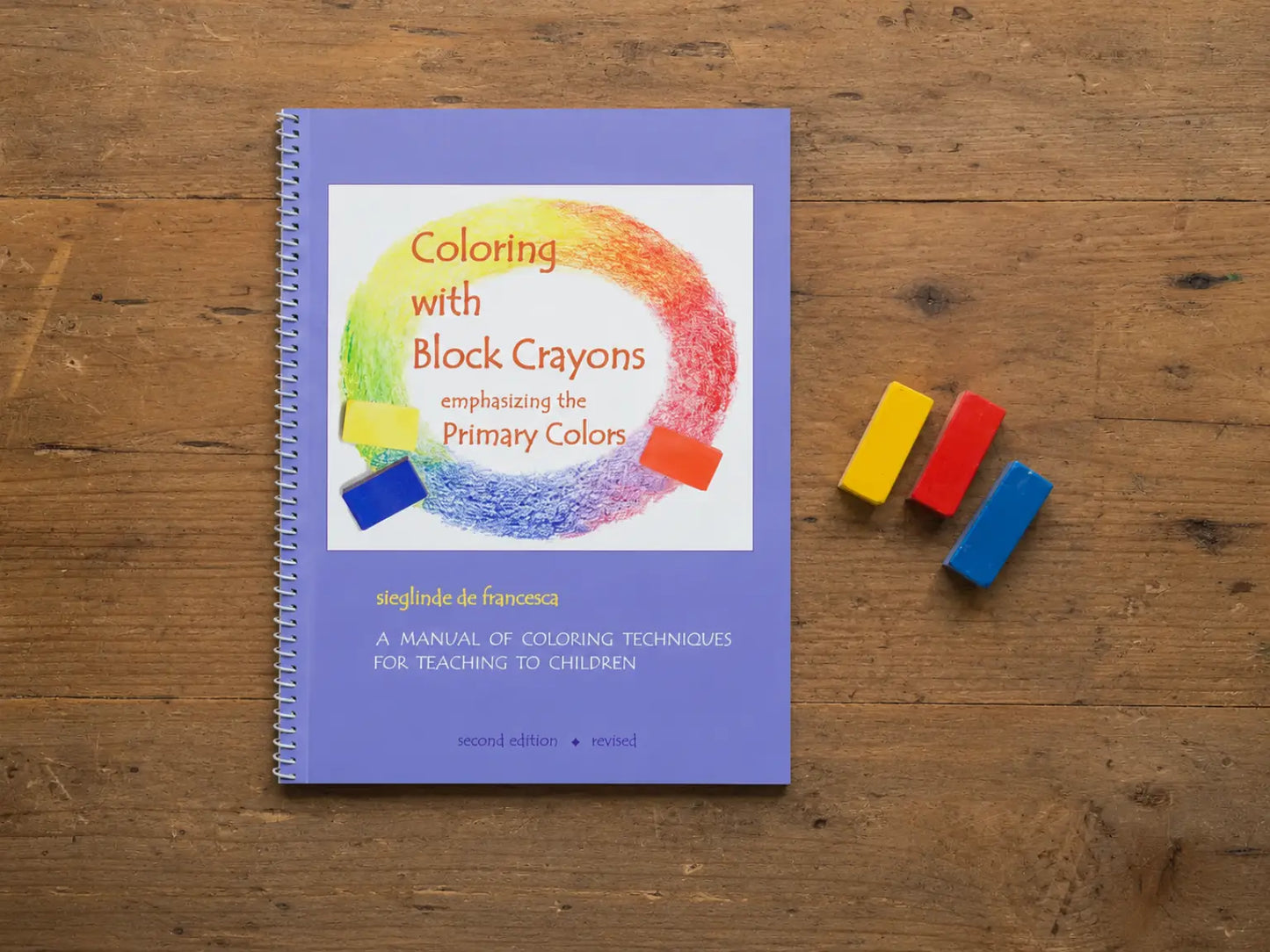 Coloring with Block Crayons book with three primary color block crayons on a wooden table