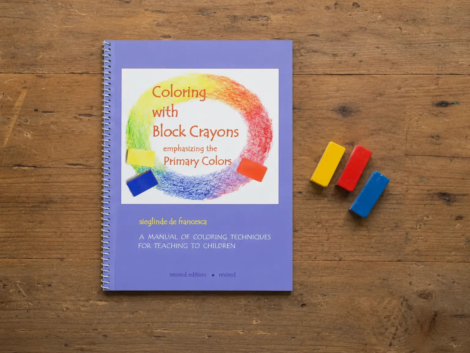 Coloring with Block Crayons book with three primary color block crayons on a wooden table