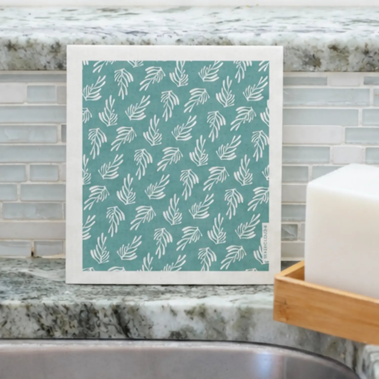 Blue-green kelp Swedish dishcloth displayed beside a kitchen sink