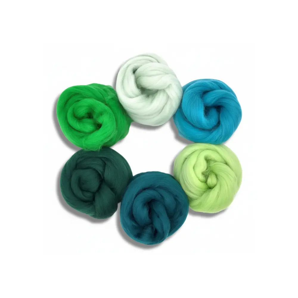 Set of colorful yarn balls in green, blue, and white on a white background