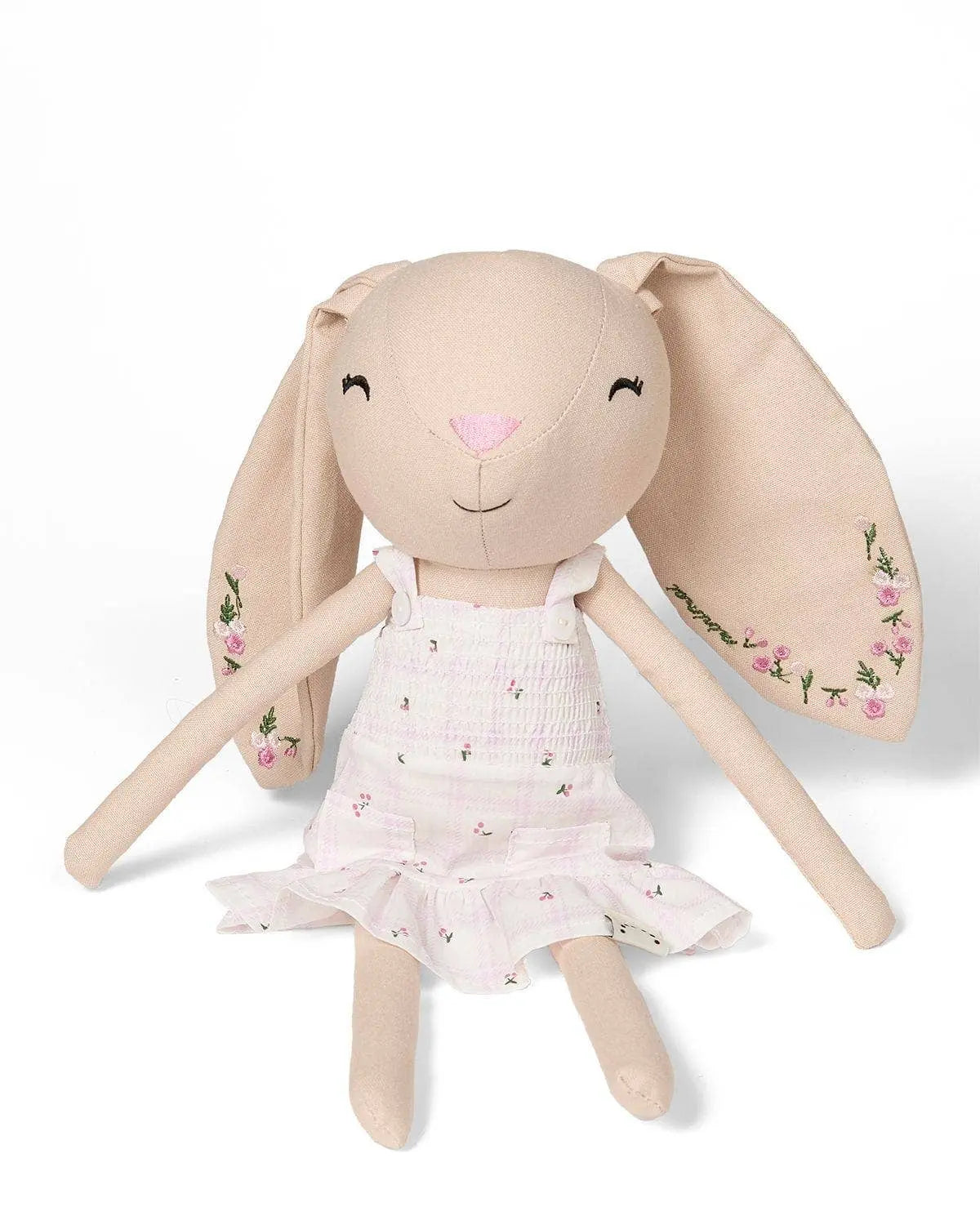 Stuffed bunny toy with a floral dress on a white background