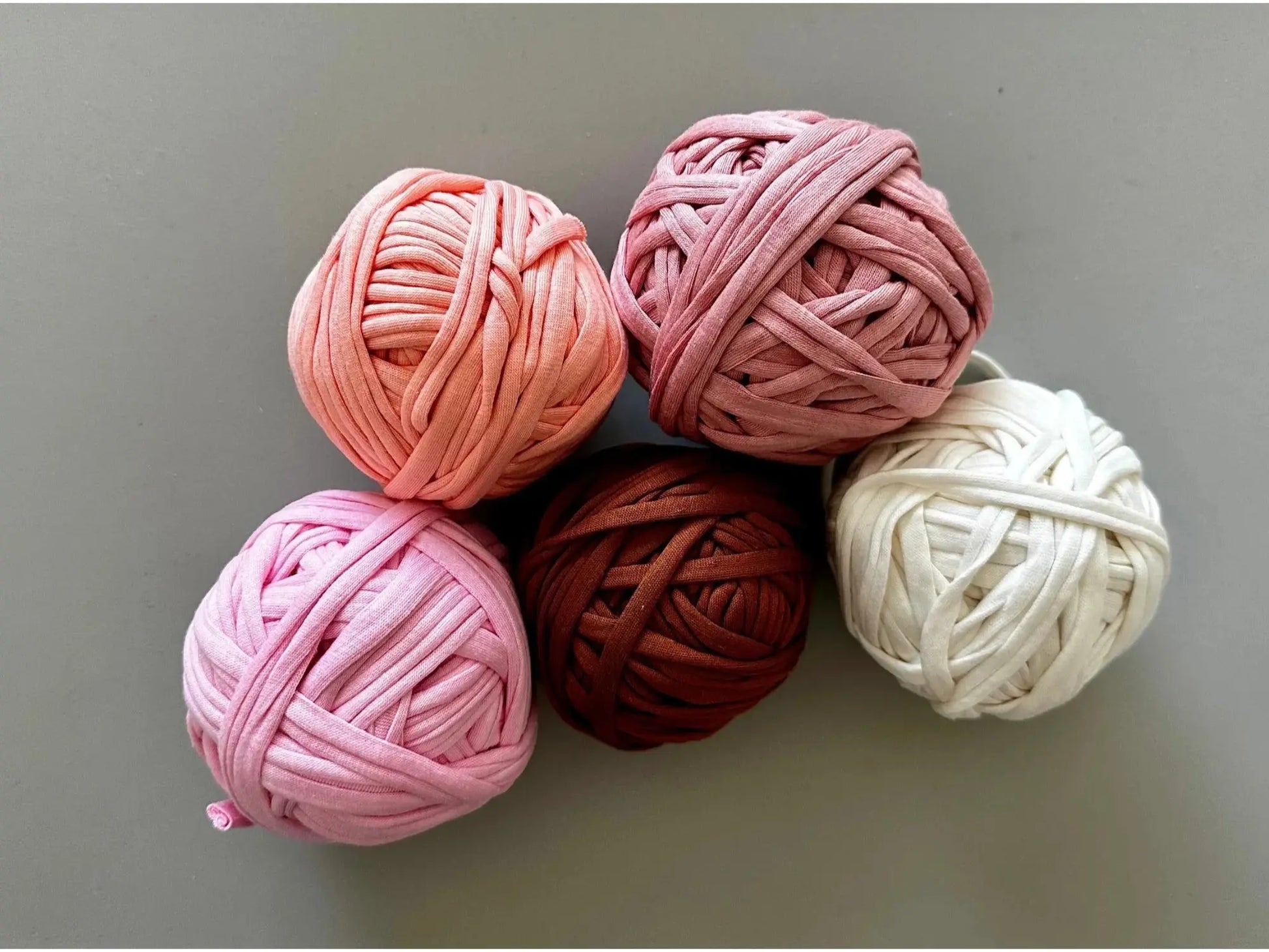 Recycled cotton tricot yarn balls in pink, red, brown, and neutral colors for weaving potholders