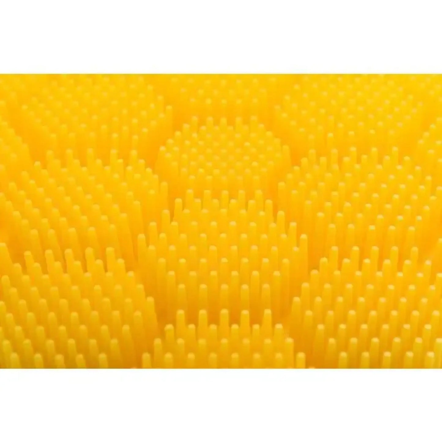 Close up of the yellow raised textured surface of the soft silicone scrubber for cradle cap, hair washing, hand washing for children