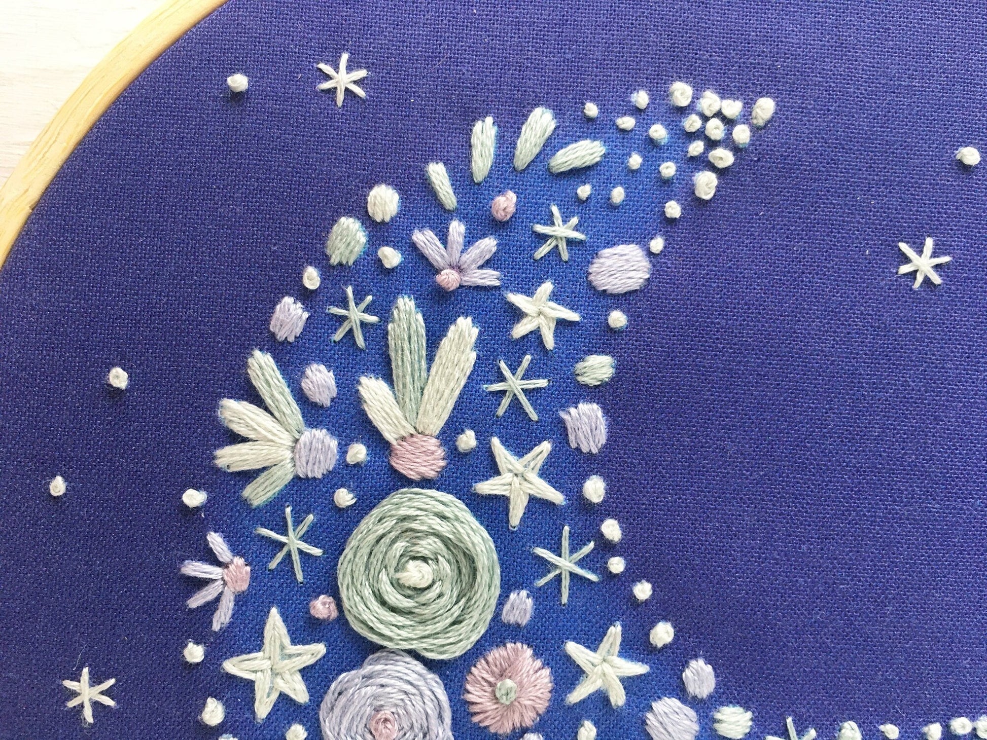 close up of crescent moon embroidery stitching showing textured thread work