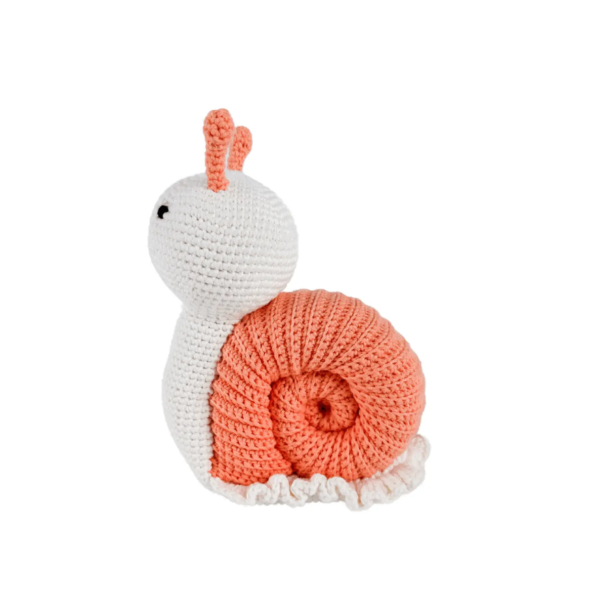 Side view of a handmade crochet snail stuffed animal showing its peach spiral shell and ruffled white base